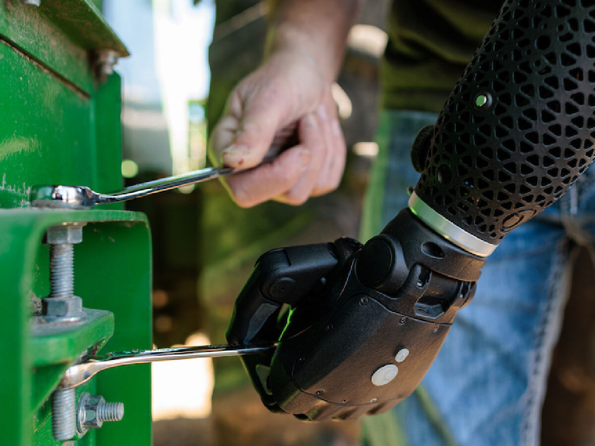 Hero RGD arm gripping a wrench to repair tractor equipment